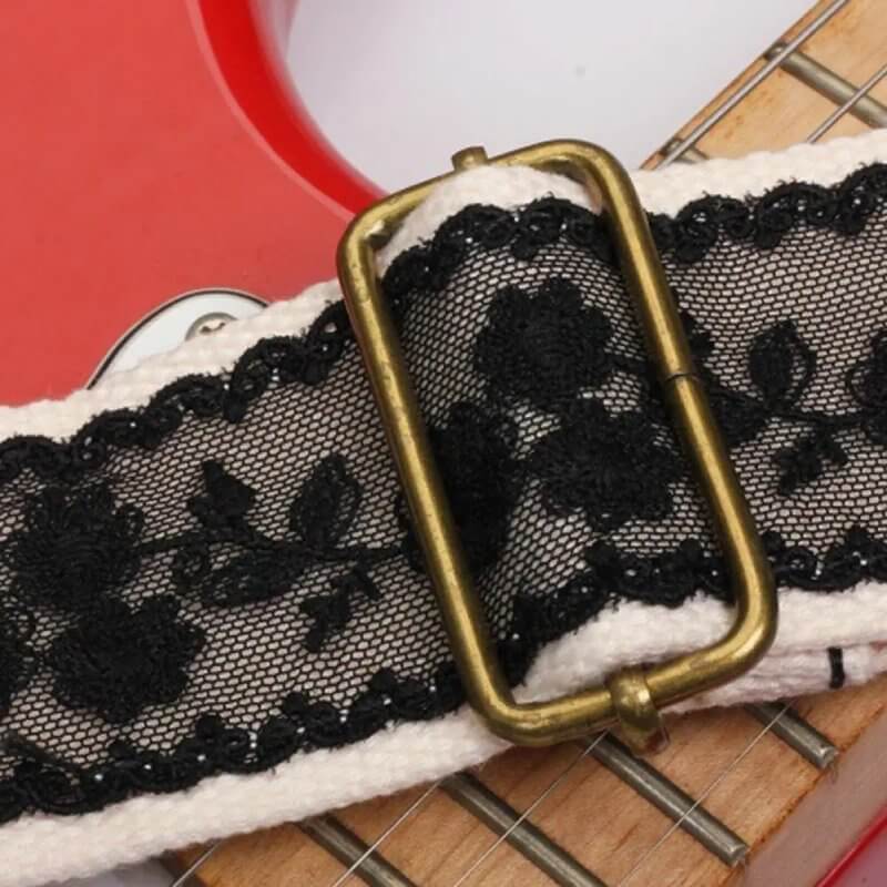 Detalles de la hebilla de la correa de guitarra con encaje floral negro