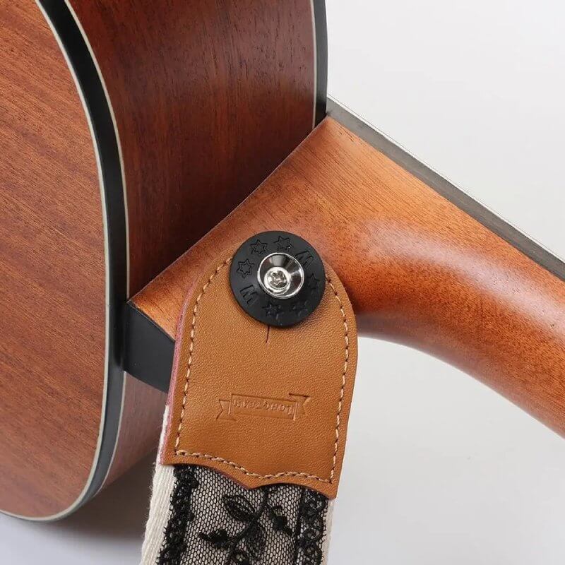 Vista de la fijación de la correa de guitarra con encaje floral negro