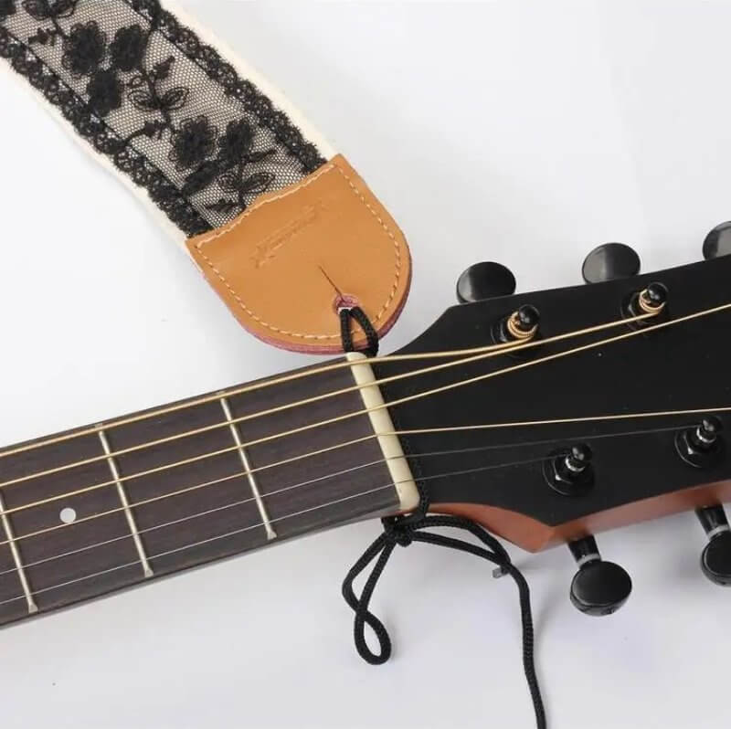 Vista de las fijaciones de la correa de guitarra con encaje floral negro