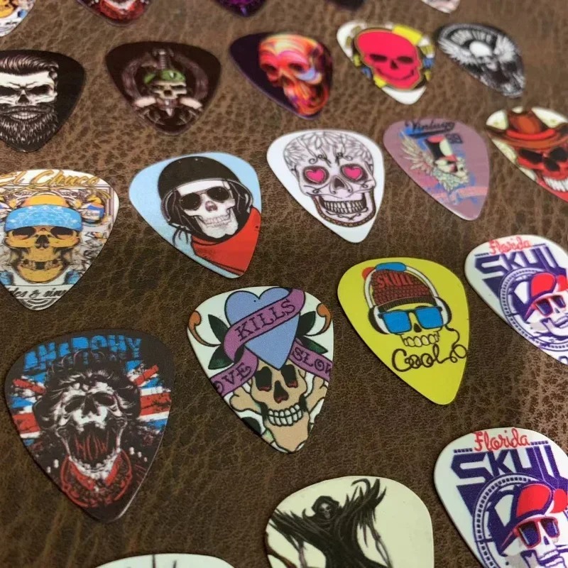 Vista detallada del conjunto de 10 púas con diseños de calaveras y cabezas de muerte de 0.46mm
