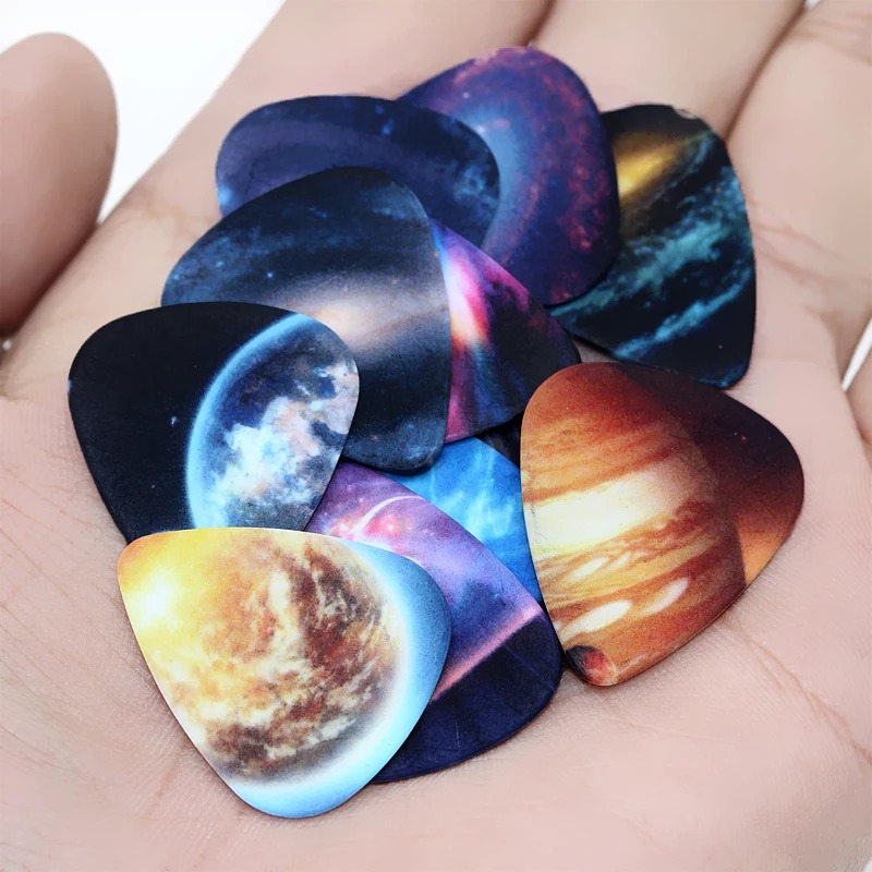 Vista completa del lote de 10 púas con motivos del Universo, Espacio, Planeta y estrellas